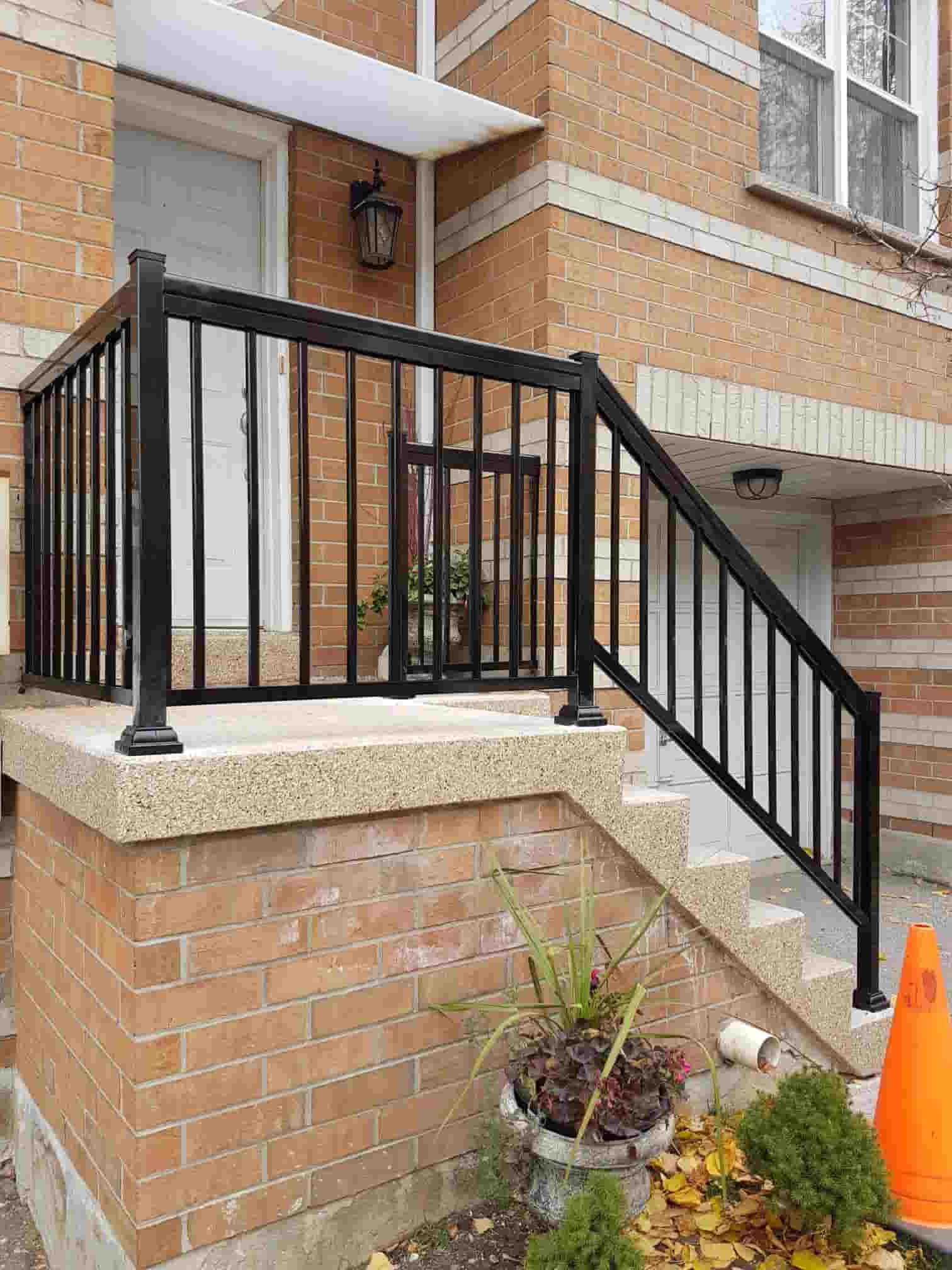 a-house-with-a-black-iron-fence-on-the-front-porch